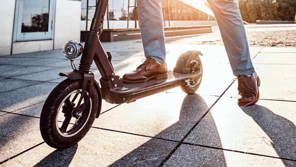 męskie stopy na hulajnodze elektrycznej w słońcu