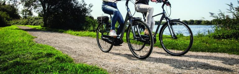 dwa rowery elektryczne na parkowej ścieżce rowerowej