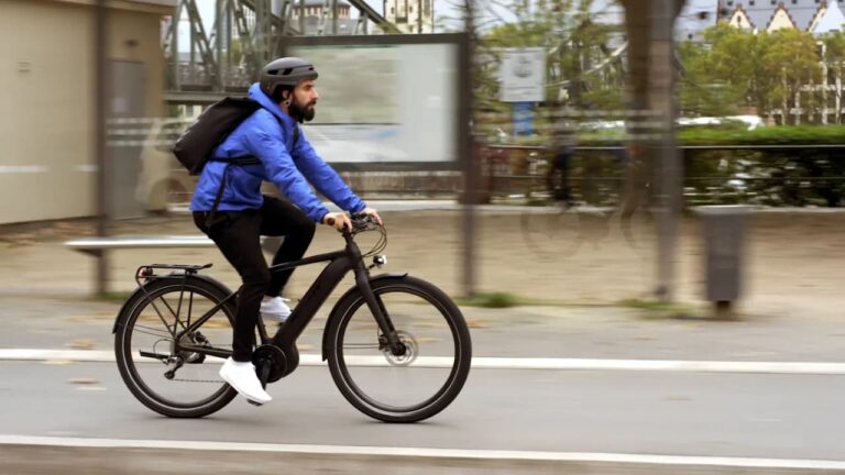 mężczyzna dojeżdżający do pracy na rowerze a w tle miasto